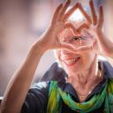 senior holds up her hands in the shape of a heart