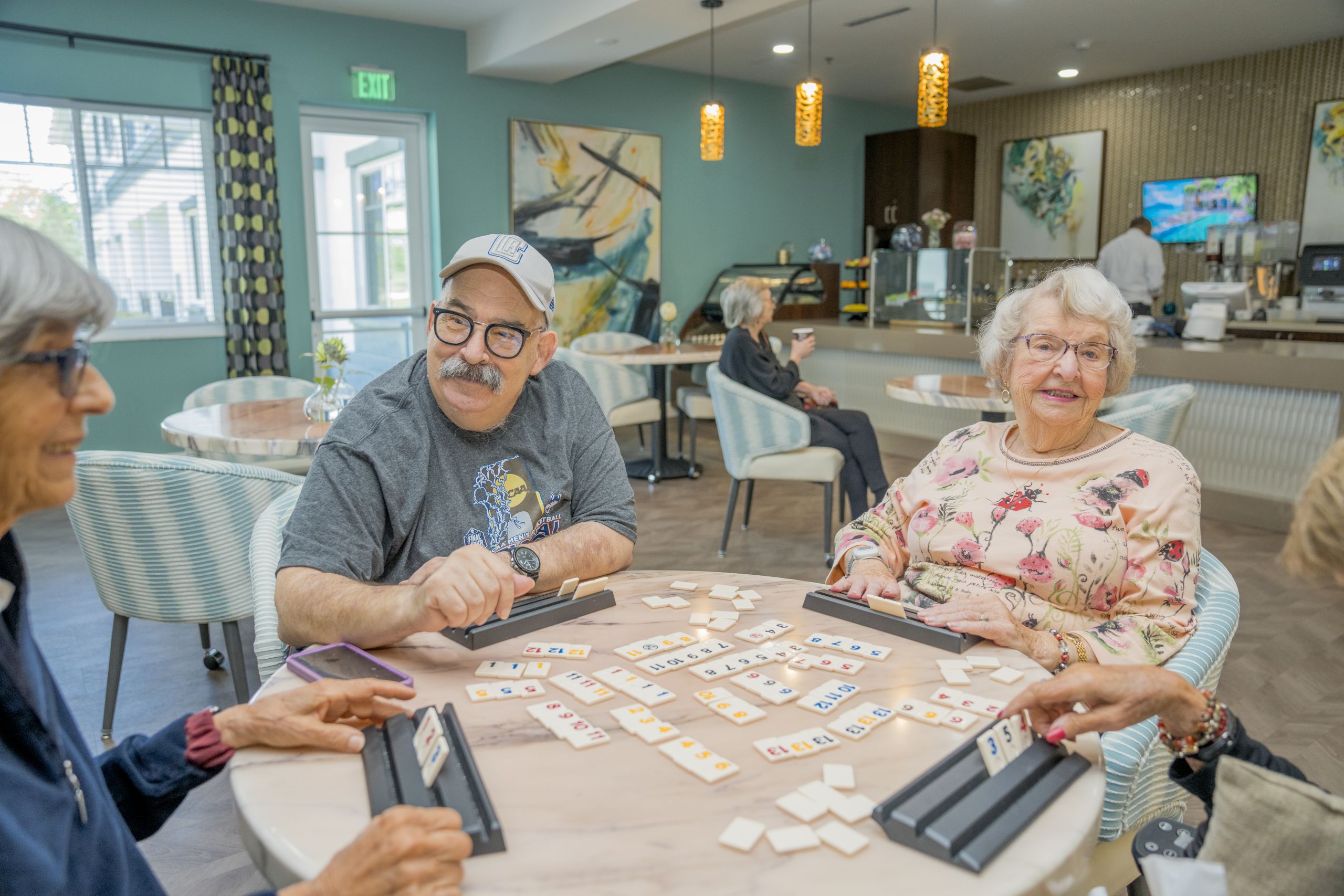 Residents of Alamar Senior Living enjoying a lively game together in the community café