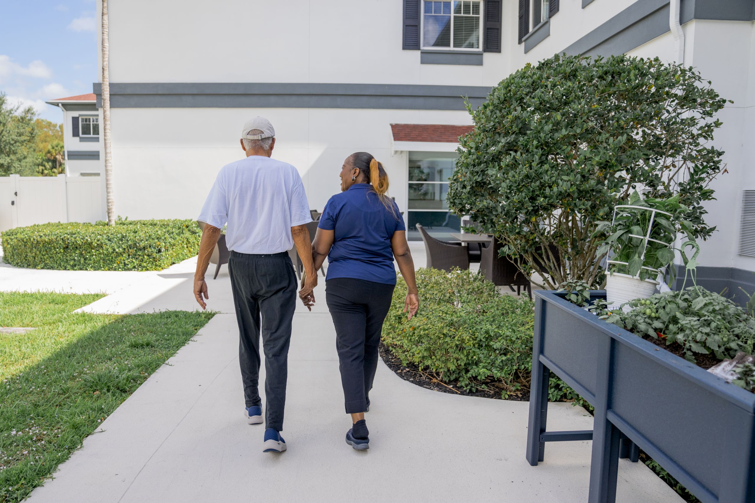 Alamar resident walking the grounds with employee.