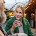 senior sips hot drink at fall festival