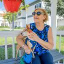 Woman sitting on the porch at a pet-friendly senior living community.